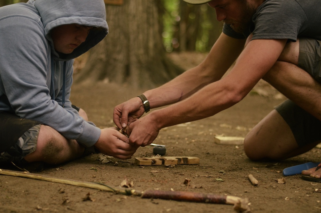Apprentice practicing fire-by-friction @ summer camp